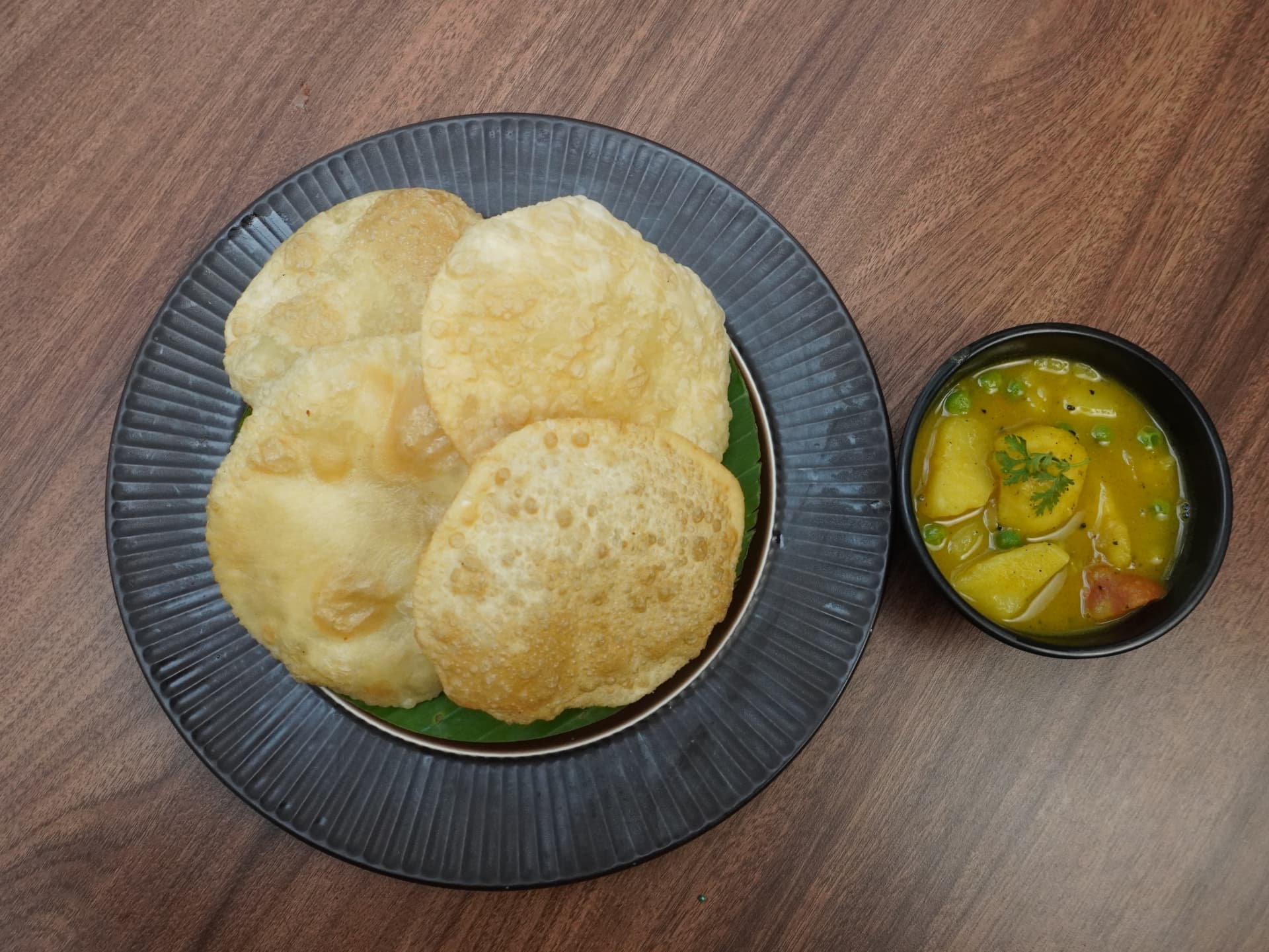 Luchi with aloor dom in a black bowl