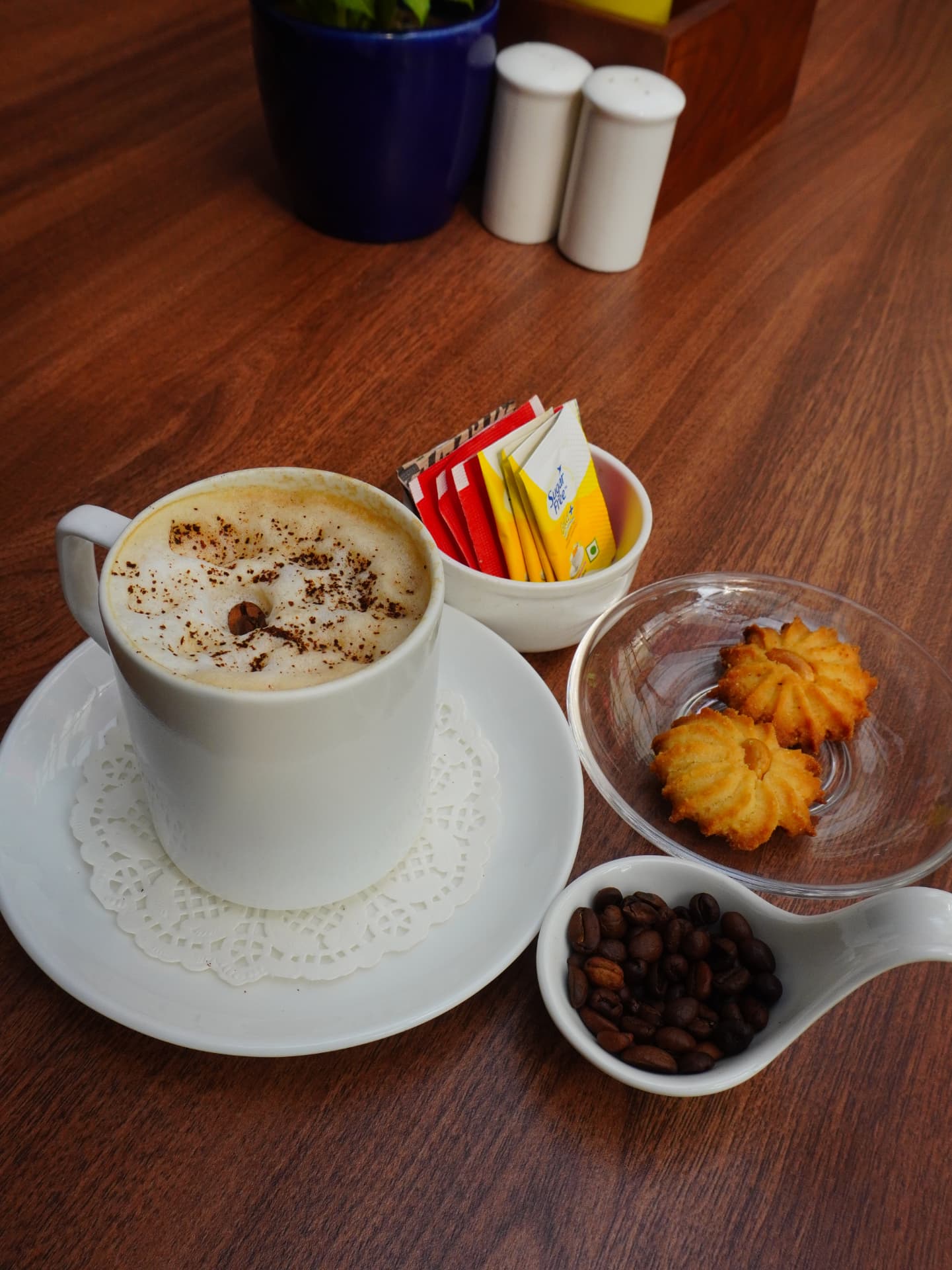 Frothy cappuccino with cookies and roasted coffee beans